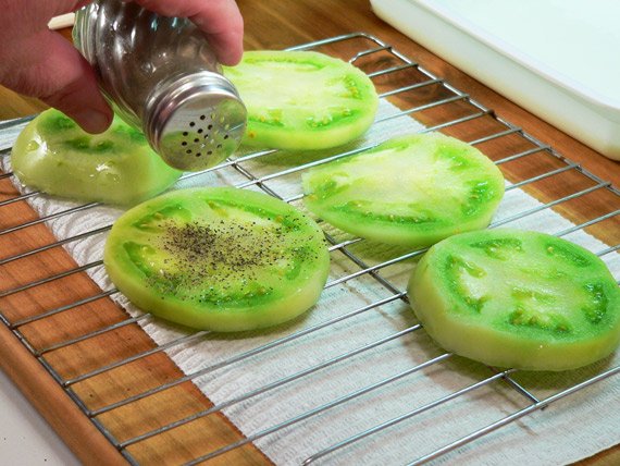 Sprinkle the green tomatoes with black pepper.